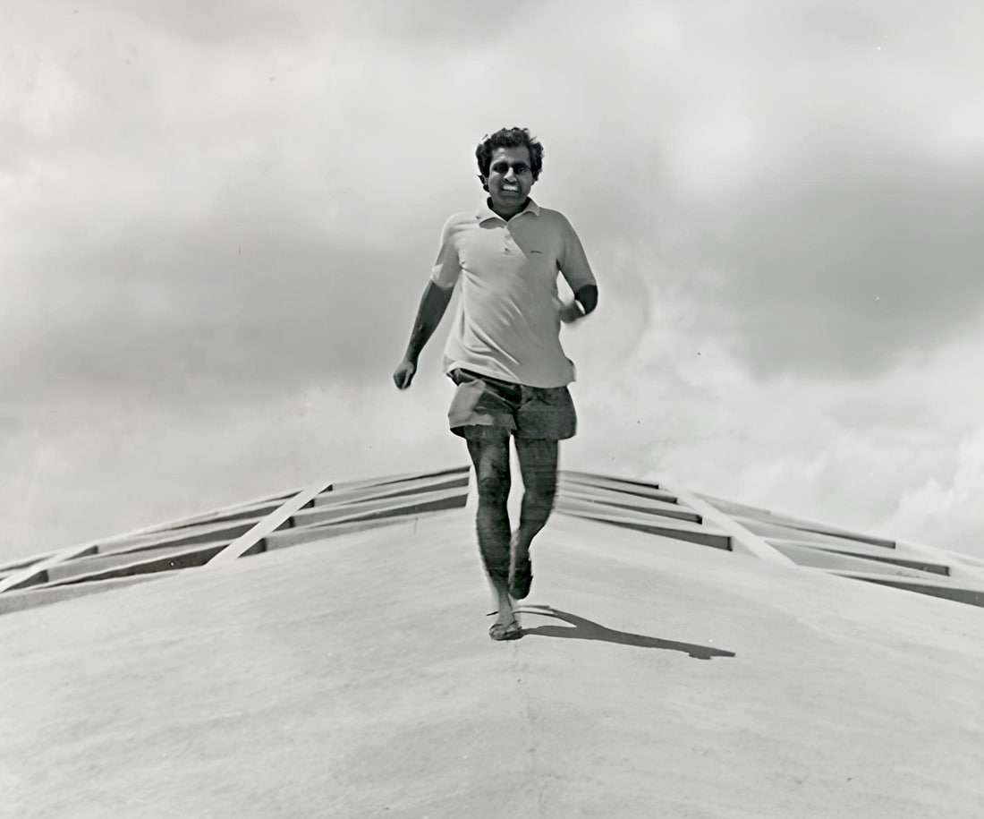 Promesse running down a curved rooftop against a cloudy sky