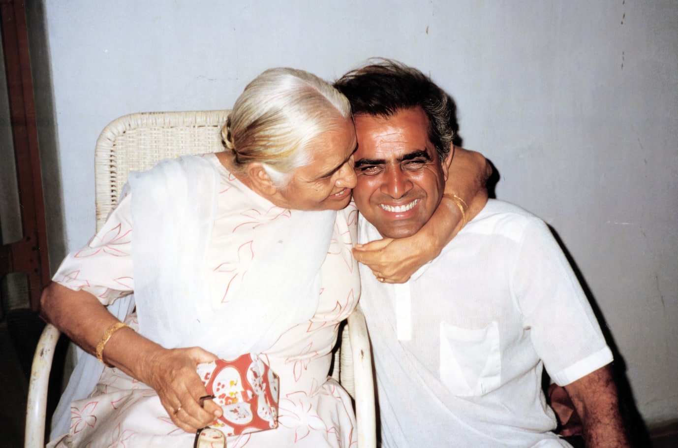 Promesse's mother resting her cheek against his, both smiling