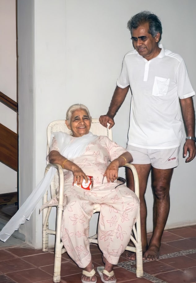 Promesse standing beside his seated mother