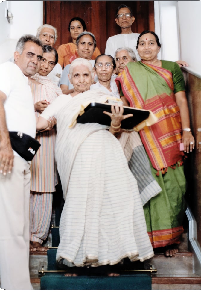 Promesse and his mother with the relics, gathered with others on the stairs
