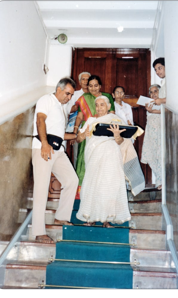 Promesse's mother carrying the relics down the stairs