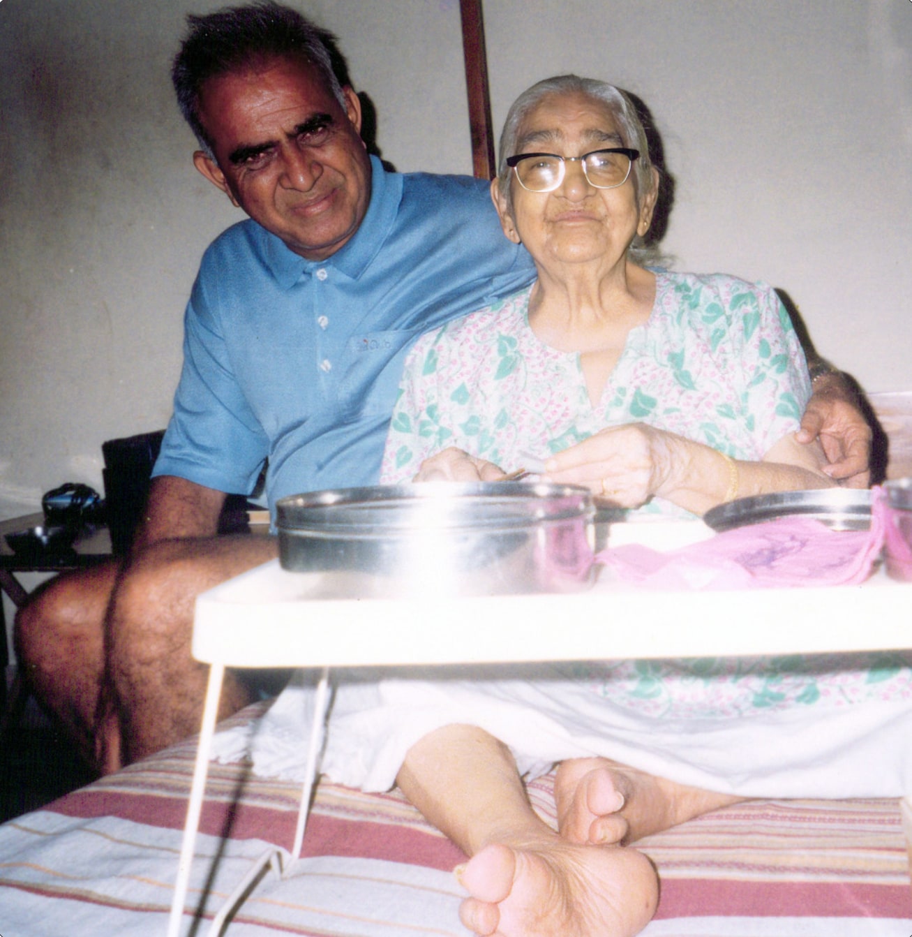 Promesse seated beside his elderly mother at her bedside